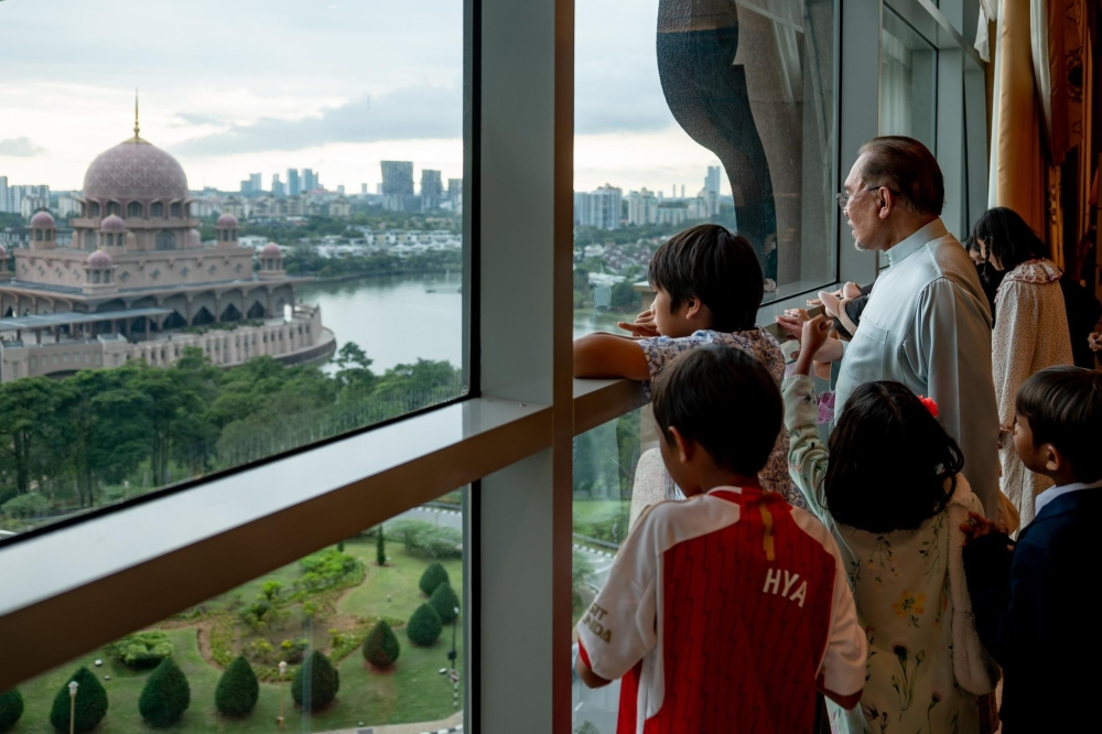 Datuk Seri Anwar Ibrahim and his grandchildren check out the view from the Prime Minister’s Office in Putrajaya. — Picture from Facebook/Anwar Ibrahim