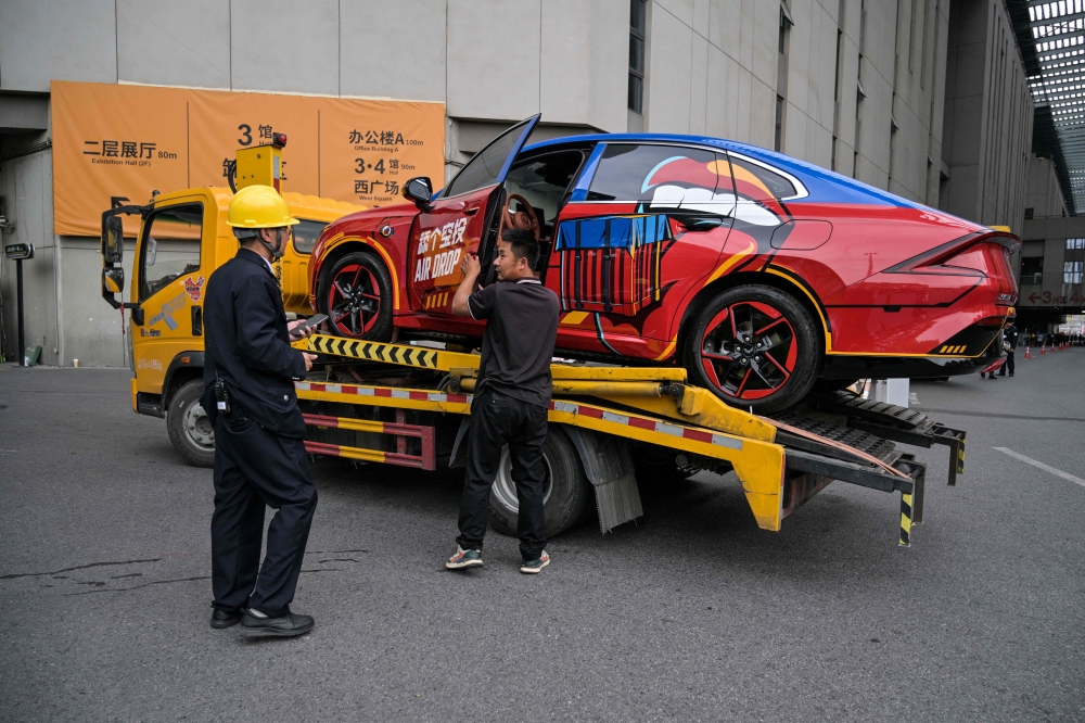 A Wuling Motors car is transported to the National Exhibition and Convention Centre to be displayed for the 21st Shanghai International Automobile Industry Exhibition in Shanghai April 21, 2025. — AFP pic