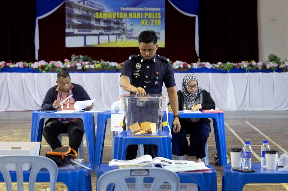 Police personnel cast their early votes for the Ayer Kuning state seat by-election at the Anggerik Hall, Tapah District Police Headquarters Housing Complex. — Bernama pic