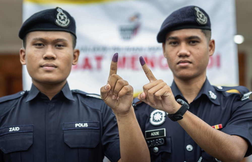 Police officers Muhammad Azizie Haqqiem Azman (right) and Muhammad Zaid Muhamad Zaidi (left) have completed their early voting responsibilities for the Ayer Kuning state by-election at the Anggerik Hall, Tapah District Police Headquarters Housing Complex today. — Bernama pic
