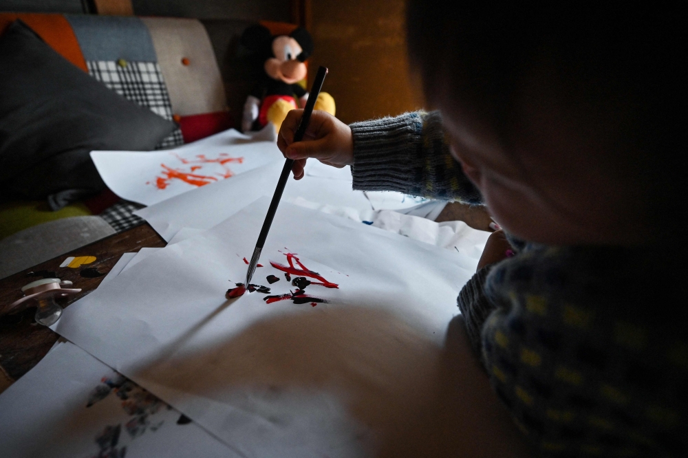 Gripping paintbrush and crayon, the artist known as Thumbelina splodges and splats with merry abandon, the one-year-old star of a Tokyo exhibition that goes on way past her bedtime. — AFP pic  
