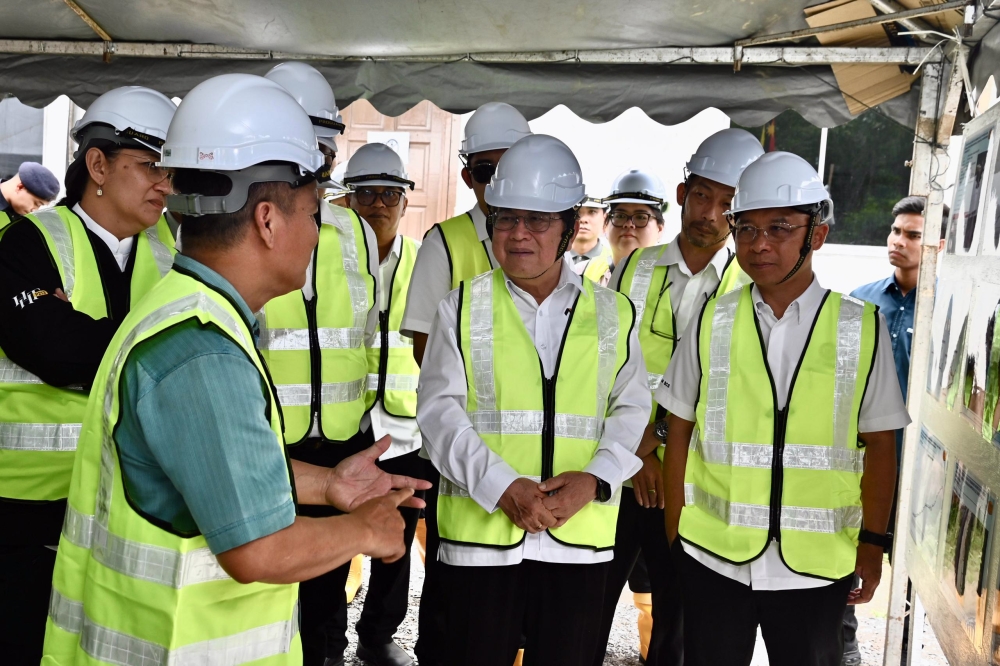 Uggah (3rd right), Cassidy (right), Hanifah (partially hidden, left) at a briefing given by the contractor’s representative. — The Borneo Post pic