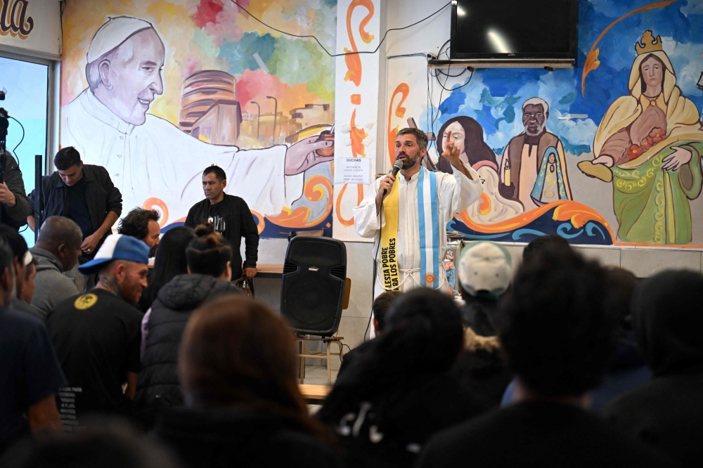 Priest Ignacio Bagattini gives a mass next to a mural depicting Pope Francis at a Hogares de Cristo center in the Padre Carlos Mujica shantytown (known as Villa 31) in Buenos Aires on April 21. — AFP pic