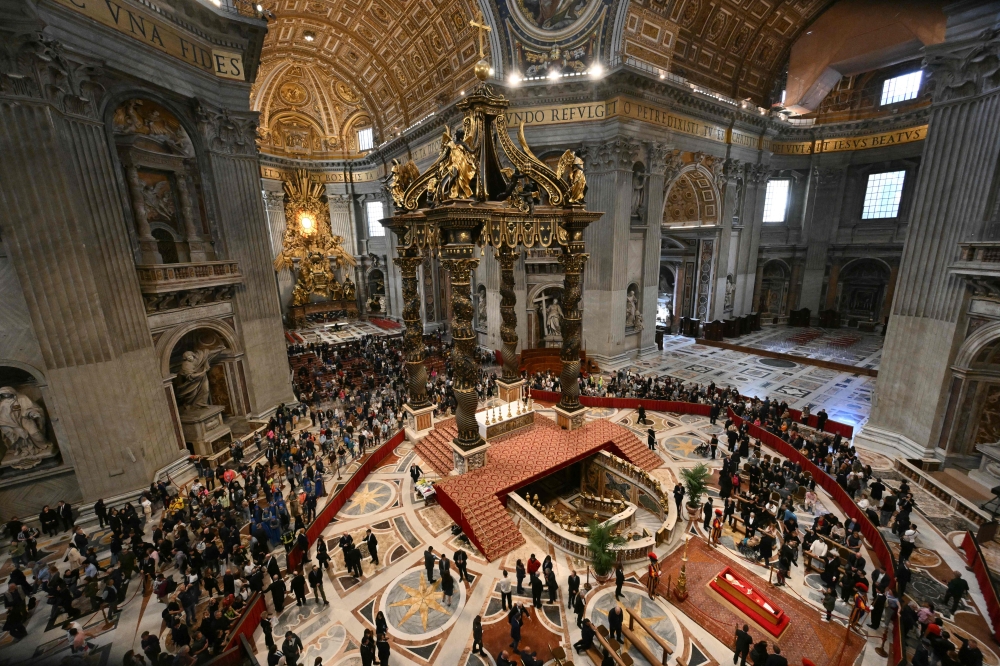 Visitors pay their respects to late Pope Francis as he lies in state in a coffin  (Bottom R) at St Peter's Basilica in The Vatican, on April 24, 2025. — AFP pic