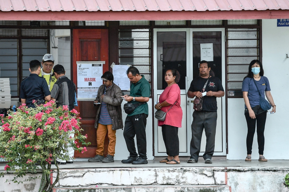 Voters queue to cast their ballots for the Ayer Kuning state by-election at the SJK(C) Sungai Kroh polling centre today. — Bernama pic