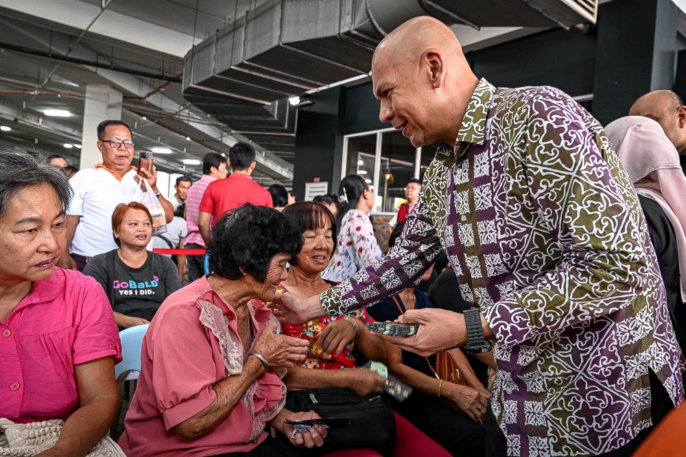 Minister of Domestic Trade and Cost of Living Datuk Armizan Mohd Ali engaged with the community during the MADANI Rahmah Sales Programme at E-mart Riam in Miri. — Bernama pic
