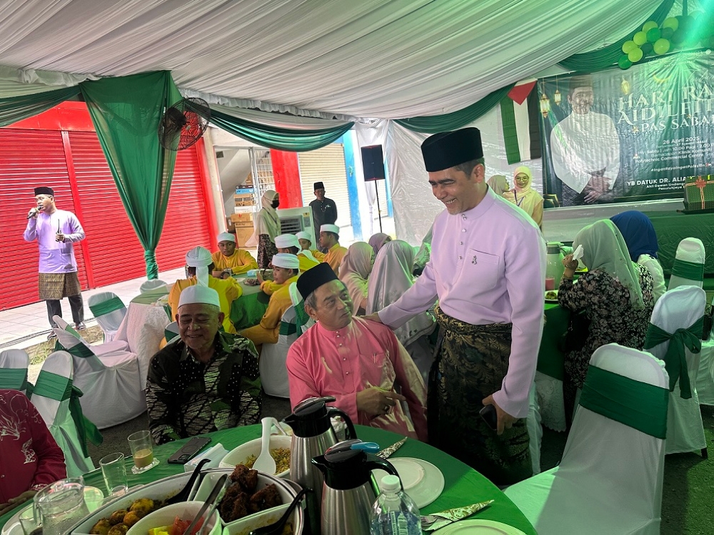 Datuk Aliakbar Gulasan (right) greeting visitors at the Sabah PAS' Raya open house. — The Borneo Post pic