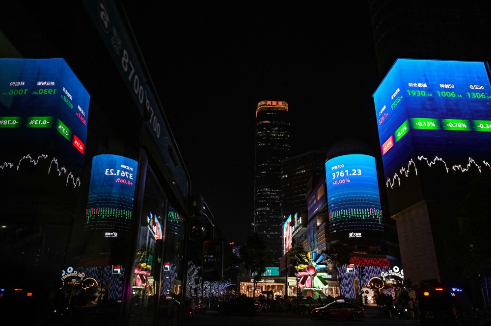 Stock market figures flash on screens displayed at a shopping mall in Guangzhou, in southern China’s Guangdong province on April 15, 2025. — AFP pic 