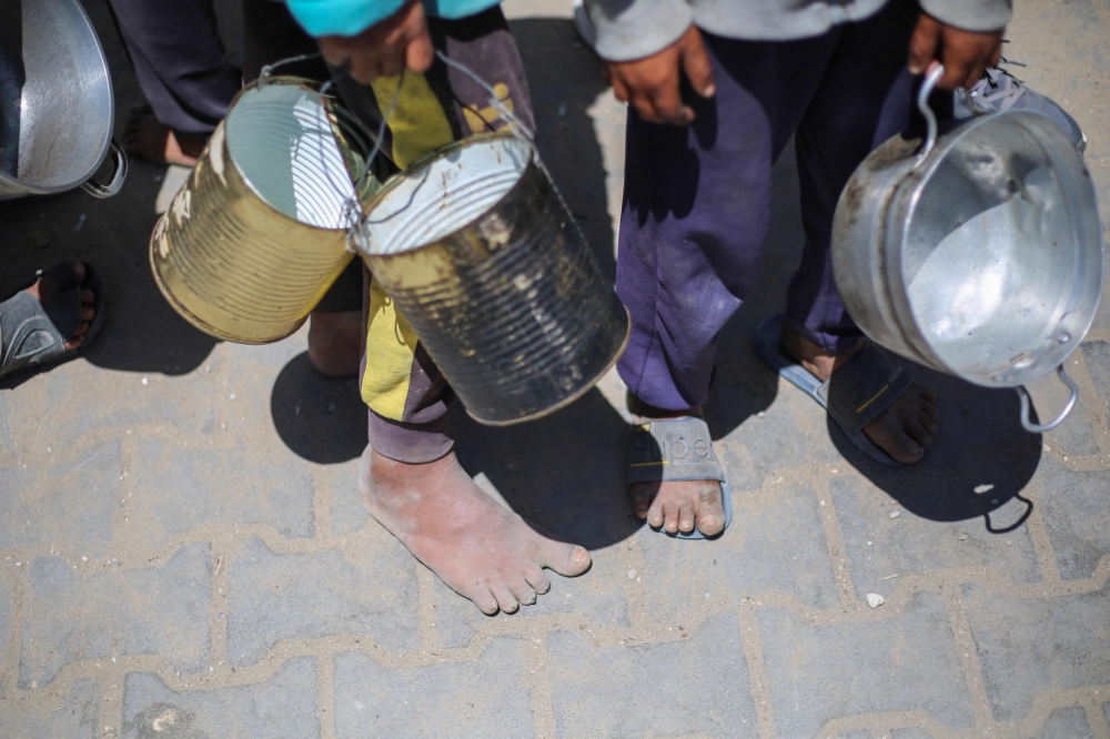 Palestinian children queue for a hot meal at a charity kitchen run by the United Nation’s World Food Programme (WFP) at the Nuseirat refugee camp in the central Gaza Strip April 26, 2025. — AFP pic