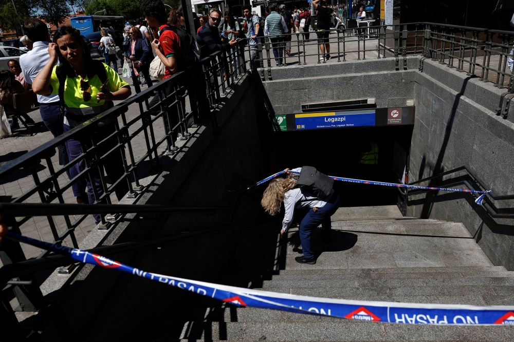 A metro worker passes underneath barricade tape, to enter Legazpi Metro station, after the metro was closed during a power outage, in Madrid, Spain, April 28, 2025. — Reuters pic 