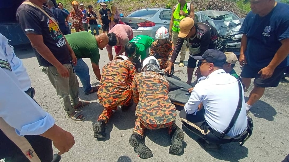 Firefighters preparing the deceased’s body to be handed to the police for further action. — Picture courtesy of the Fire and Rescue Department 