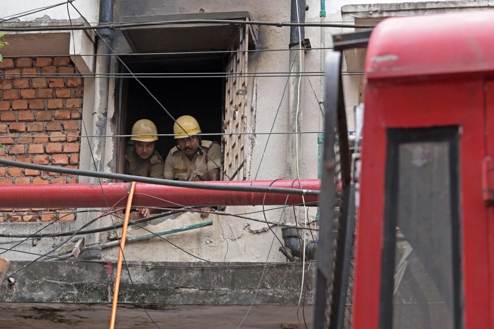 Firefighters inspect the Rituraj Hotel where a fire brokeout, in Kolkata on April 30, 2025. — AFP pic