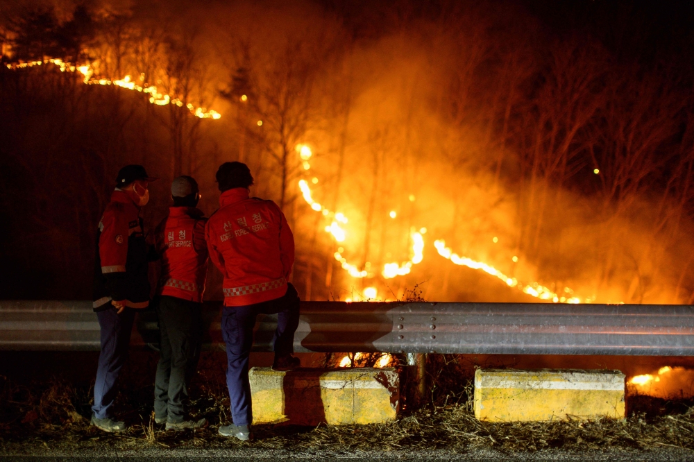 In this file picture taken early on March 27, 2025, Korea Forest Service personnel observe a wildfire from the side of a road in Andong. — AFP pic 