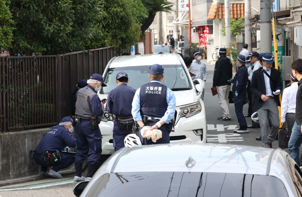 Police officers investigate the scene in Osaka’s Nishinari district on May 1, 2025, after a man was arrested after allegedly ploughing his car into seven schoolchildren in a suspected deliberate attack, local media said. — Jiji Press handout pic via AFP 