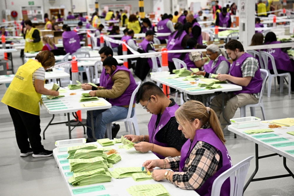 Australian Electoral Commission staff count ballots during the 2025 federal election at the Ingleburn OPC in Sydney, Australia, May 3, 2025. — AAP Images via Reuters pic