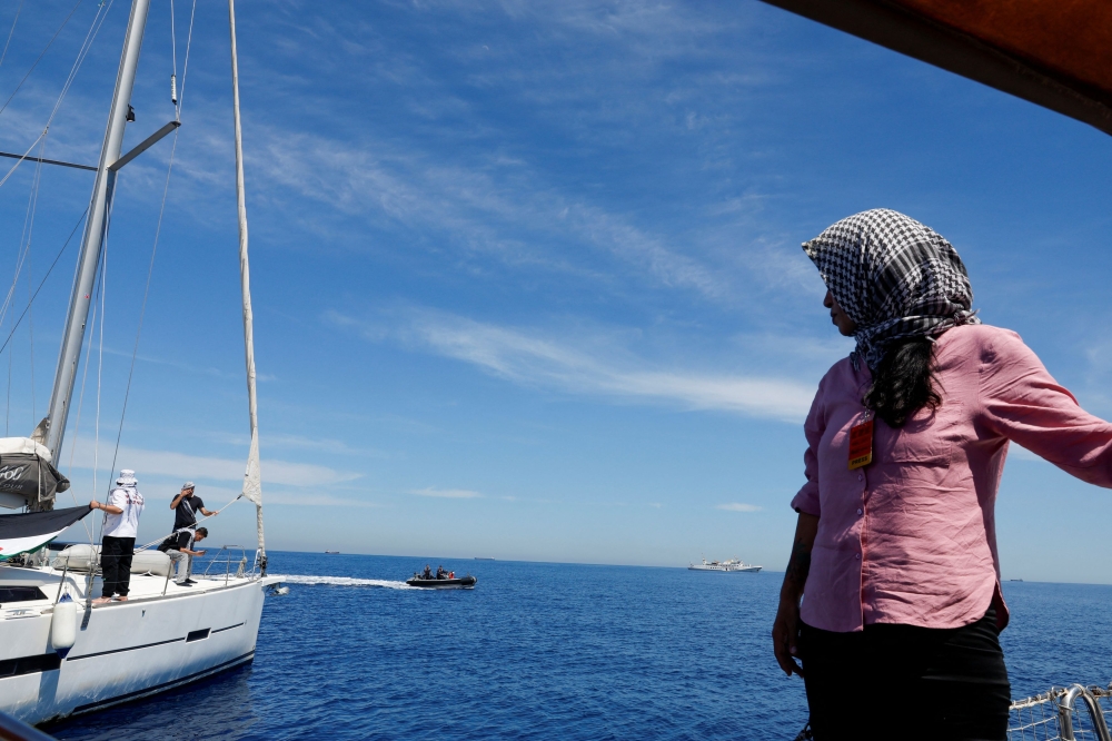 People stand on boats as activists are prevented from approaching the damaged Gaza Freedom Flotilla vessel ‘Conscience’, after it was bombed by drones while carrying humanitarian aid to Gaza, at sea outside Maltese territorial waters, May 3, 2025. — Reuters pic