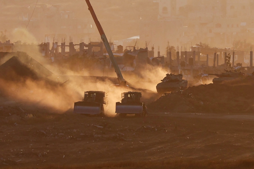 Israeli army vehicles are deployed at a position by Israel's border with the Gaza Strip yesterday. — AFP pic