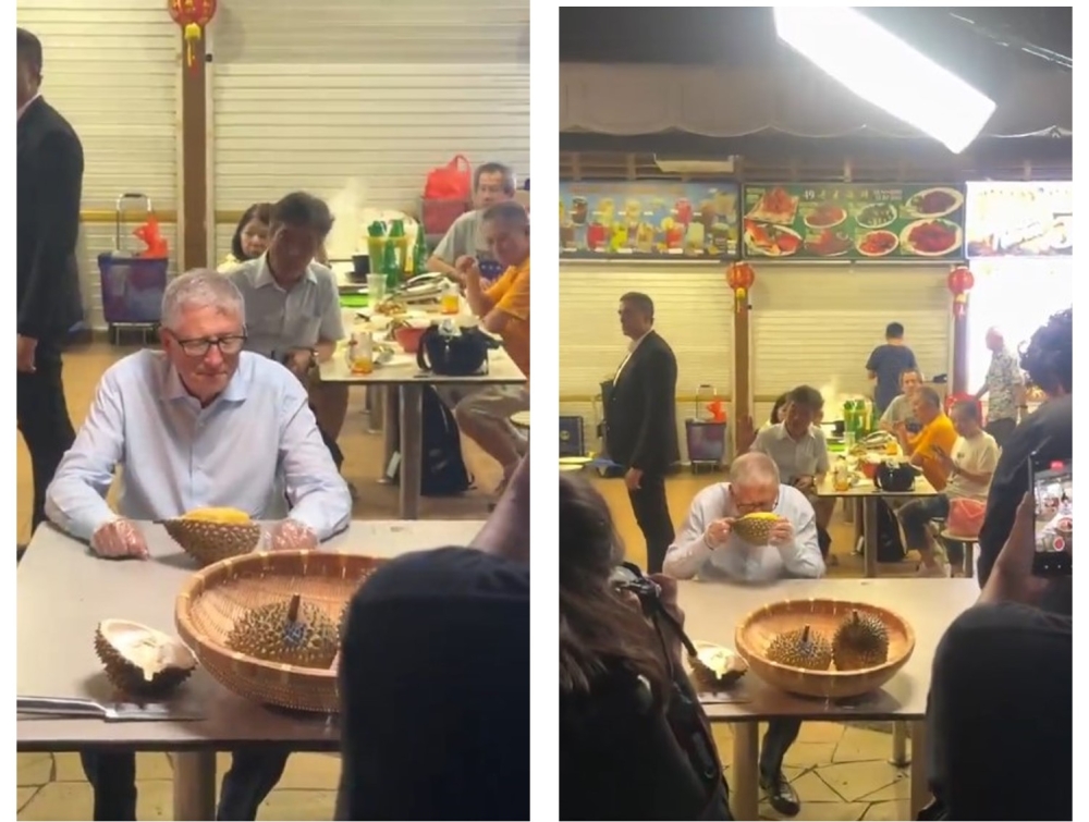 Bill Gates pauses to smell a durian before eating it at Newton Food Centre, Singapore yesterday. — Screengrab via Facebook/Gabriel Ryan Adaikalam