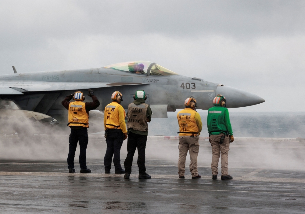 Crew members signal to a F/A-18E Super Hornet fighter jet preparing to take off for a routine flight on board the US USS Nimitz aircraft carrier during a routine deployment to the South China Sea in this file photo taken on January 27, 2023. An F/A-18 Hornet fighter jet belonging to the Finnish Air Force crashed near an airport in northern Finland today. — Reuters pic