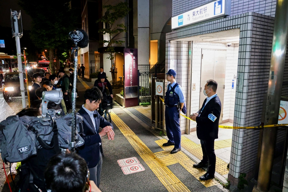 Police officers stand guard at an entrance of Todai-mae Station on Tokyo Metro’s Namboku Line after a stabbing incident in Tokyo May 7, 2025. — AFP pic