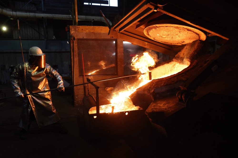 An employee works at Le Creuset foundry during a press visit to mark the brand's 100th anniversary in Fresnoy-le-Grand, on April 29, 2025. — AFP pic
