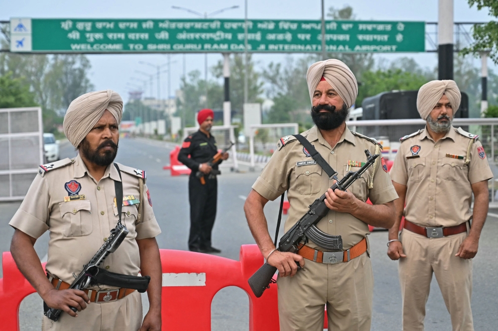 Policemen stand guard on the entrance road of the Sri Guru Ram Dass Jee International Airport on the outskirts of Amritsar May 7, 2025. — AFP pic