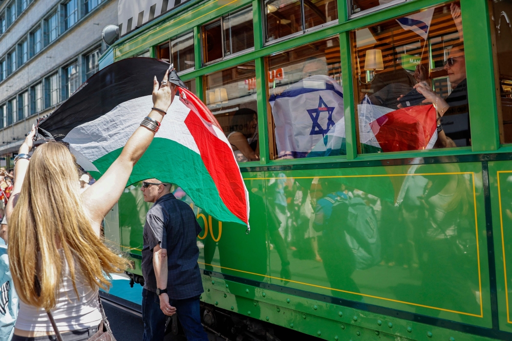 A protestor (left) holds a Palestinian flag as she takes part in a demonstration against Israel's team (R) during the Eurovision Song Contest 2025 opening ceremony in Basel on May 11, 2025. — AFP pic