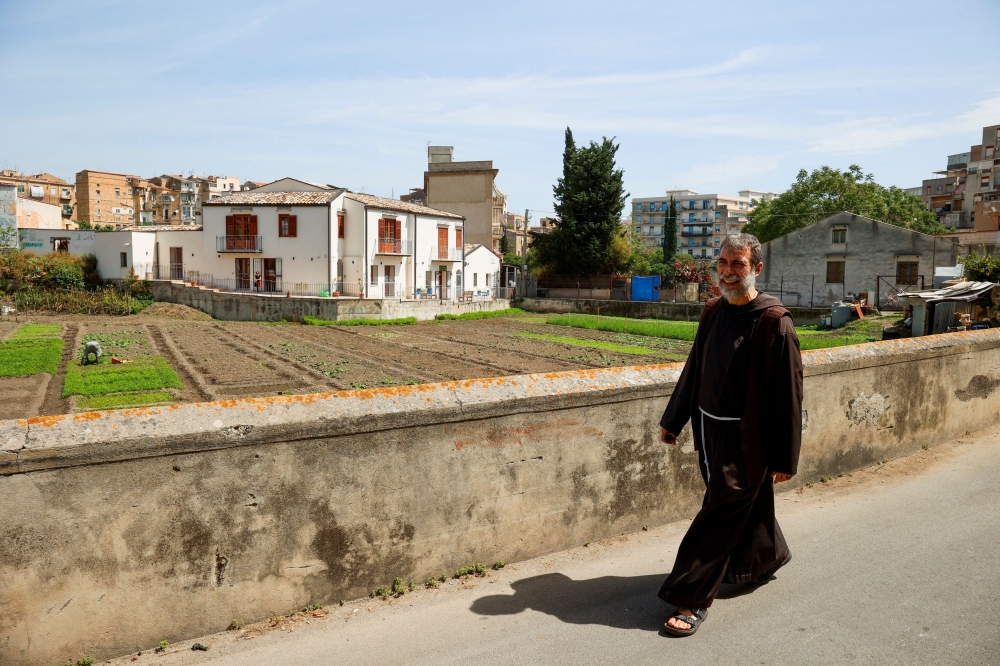 Franciscan friar Mauro Billetta walks in front of the white B&B opened near the Saint Agnese parish that he manages in Danisinni district, Palermo, May 5, 2025. — Reuters pic
