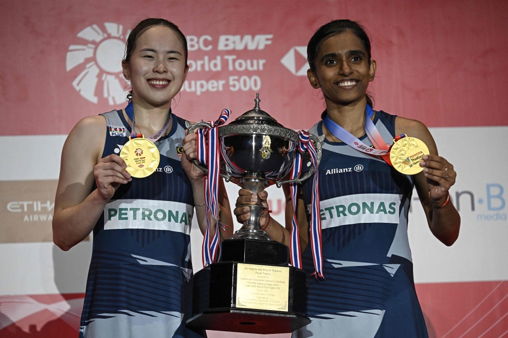 Malaysia’s M. Thinaah and Pearly Tan hold the women’s doubles trophy after winning against second-placed South Korea’s Jeong Na-eun and Lee Yeon-woo at the 2025 Thailand Open in Bangkok May 18, 2025. — AFP pic