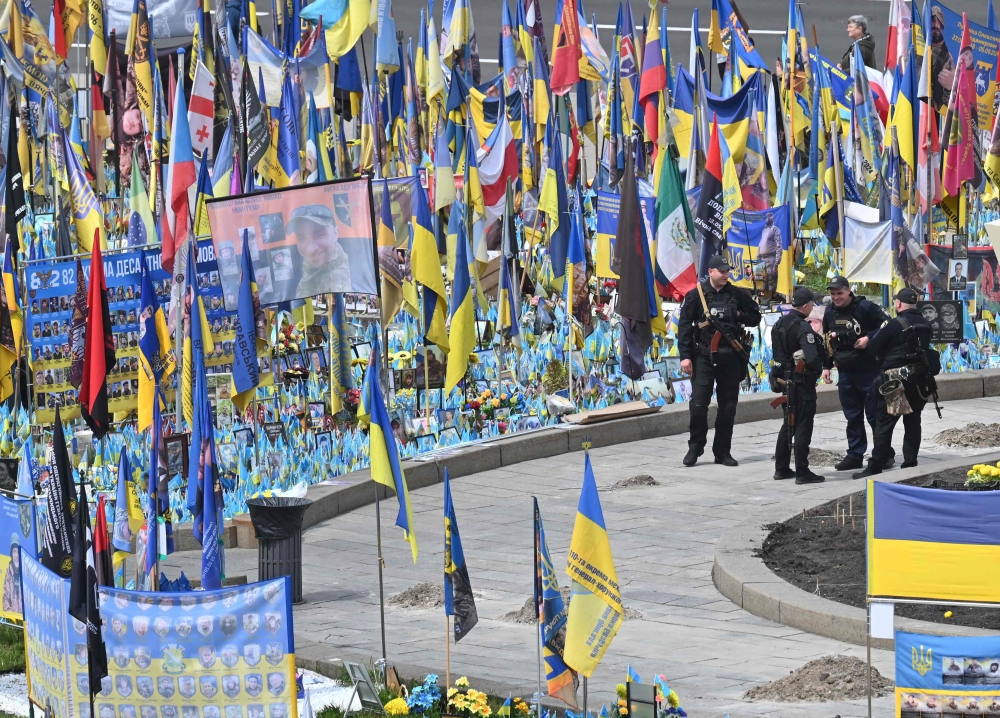 Police officers stand guard at a makeshift memorial for the fallen Ukrainian and foreign fighters in the Independence Square in Kyiv on May 19, 2025, amid the Russian invasion of Ukraine. — AFP pic
