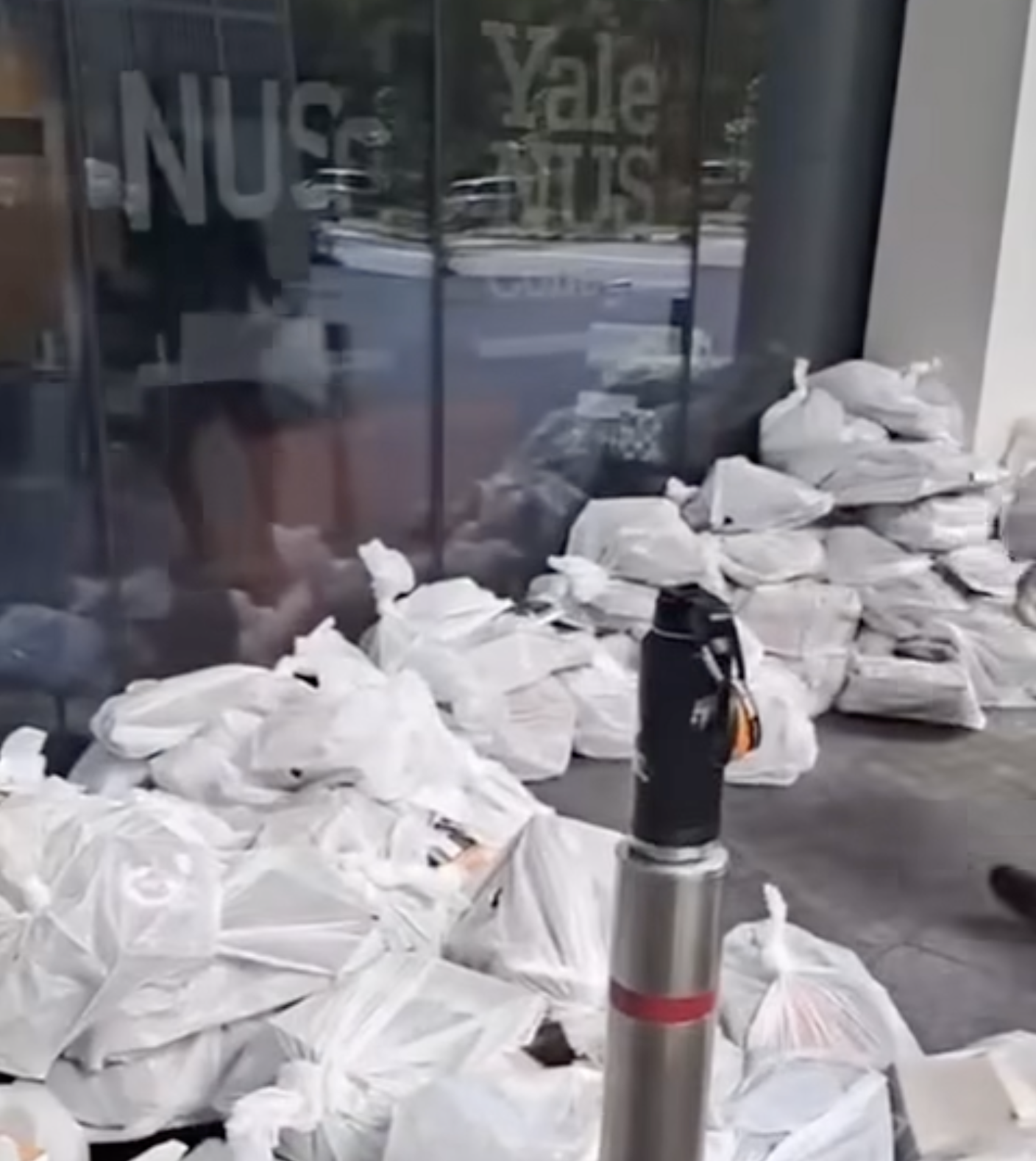 Screengrab of a video showing books from the Yale-NUS College library packed into trash bags before they are loaded onto a recycling truck. 