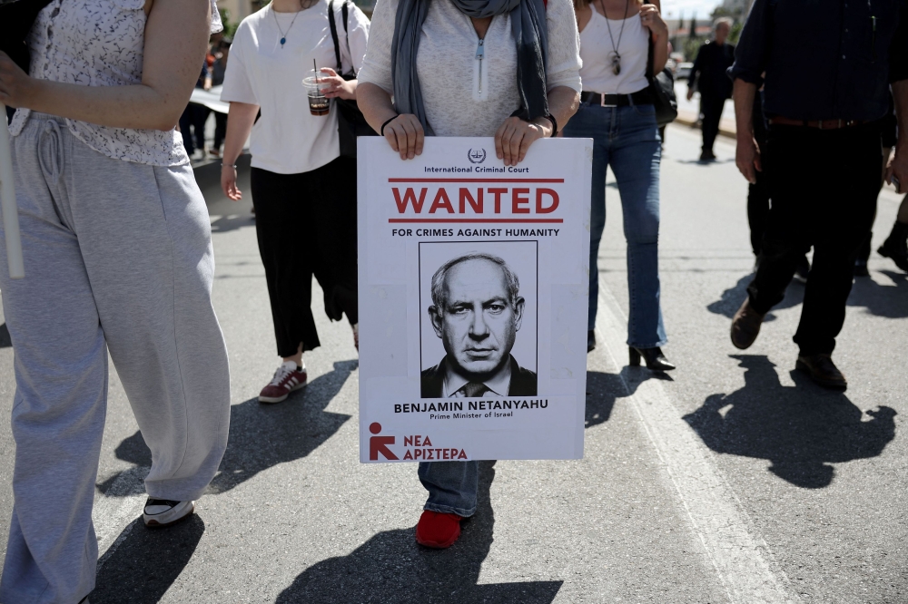 A person holds a poster depicting Israeli Prime Minister Benjamin Netanyahu during a pro-Palestinian march towards the Israeli embassy, amid the ongoing conflict between Israel and Hamas, in Athens, Greece, May 17, 2025. — Reuters pic