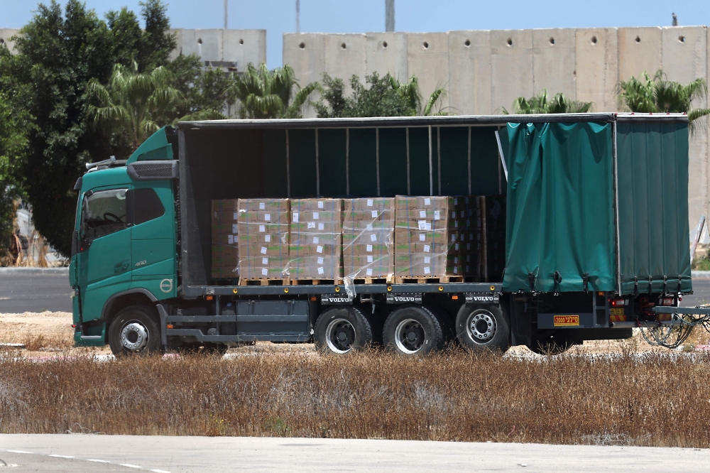 A truck carrying aid makes its way to the Gaza Strip from the Israeli Kerem Shalom crossing, on May 20, 2025, amid the ongoing war with the Palestinian militant movement Hamas. — AFP pic