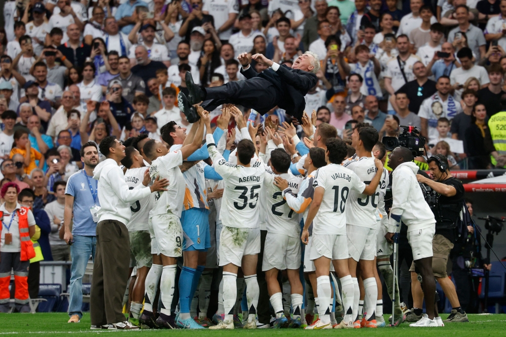 Real Madrid’s Italian coach Carlo Ancelotti is tossed into the air by players at the end of the Spanish league football match between Real Madrid and Real Sociedad. — AFP pic