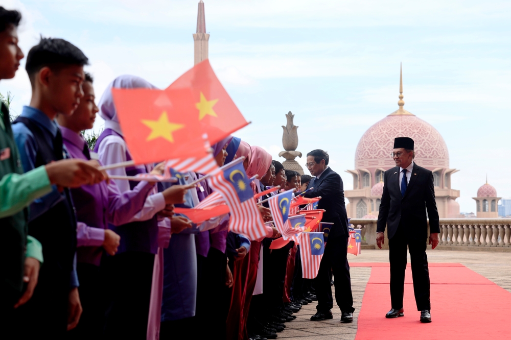 Vietnamese Prime Minister Pham Minh Chinh greets schoolchildren as Prime Minister Datuk Seri Anwar Ibrahim looks on, in Putrajaya May 25, 2025. — Bernama pic