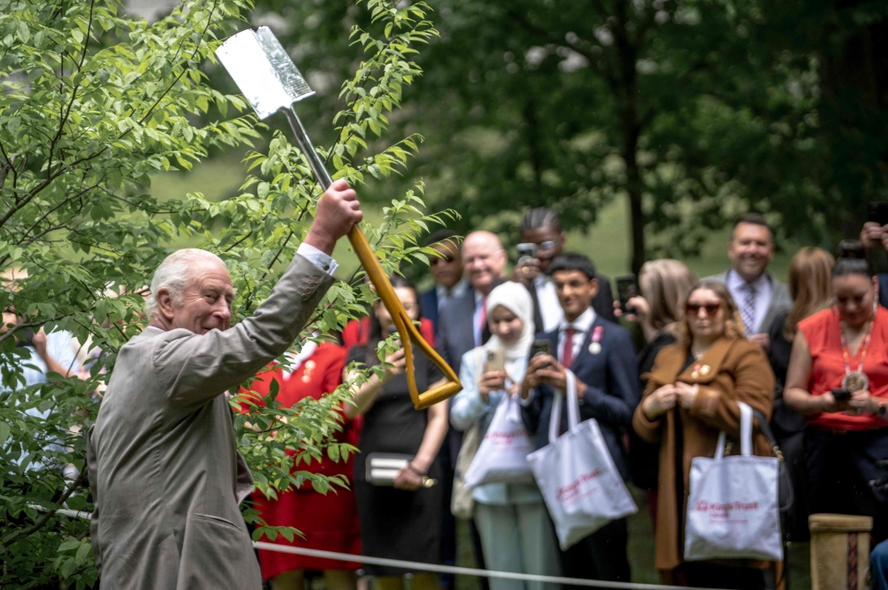 Britain’s King Charles III gestures with a shovel after participating in a ceremonial tree planting at the official residence of the Governor General of Canada, Rideau Hall, in Ottawa, on May 26, 2025. — AFP pic
