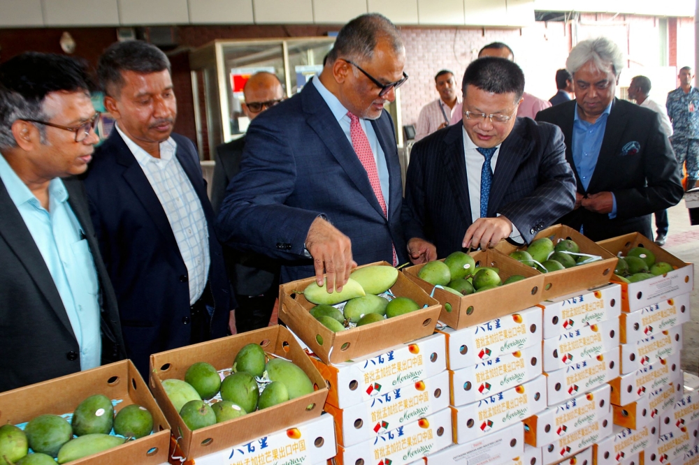 Bangladesh’s Ministry of Commerce advisor Sheikh Bashir Uddin (third from left) and China’s ambassador to Bangladesh Yao Wen (second from right) inspect mango caskets during a ceremony at the Hazrat Shahjalal International Airport in Dhaka on May 28, 2025. — AFP pic