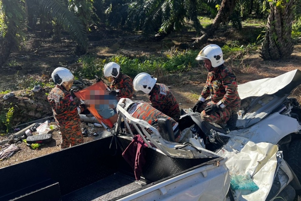 Firefighters extricating the victim from the wreckage after a road accident near the Nyalau Bridge along Jalan Pesisir Bintulu-Miri yesterday. — Picture courtesy of the Fire and Rescue Department .