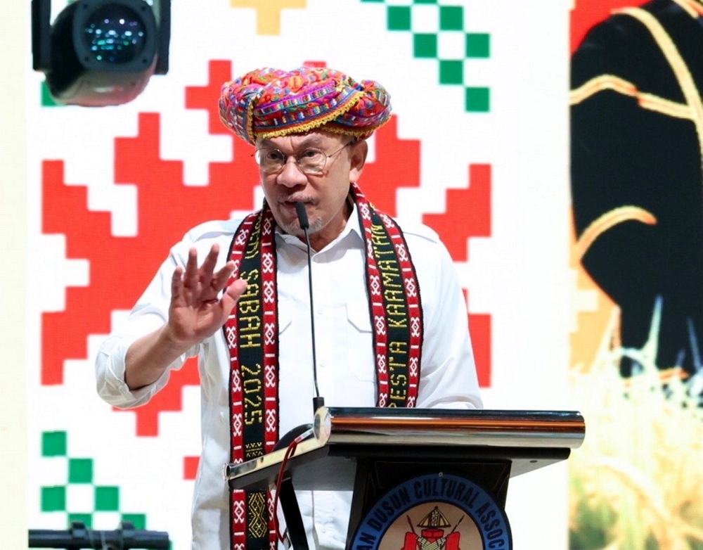Prime Minister Datuk Seri Anwar Ibrahim, wearing a Rungus Kudat tribal Sigar, delivers the opening speech in conjunction with the Sabah state-level Kaamatan Festival celebration at the Hongkod Koisaan Hall, Kadazandusun Cultural Association (KDCA), Penampang May 30, 2025. — Bernama pic