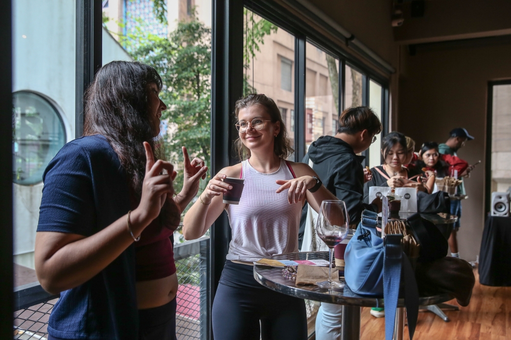 Have caffeine, talk flows: Julia (white shirt) and Hershey (left) get into deep discussion during the coffee rave event at UP Kuala Lumpur on May 31, 2025. — Picture by Yusof Mat Isa