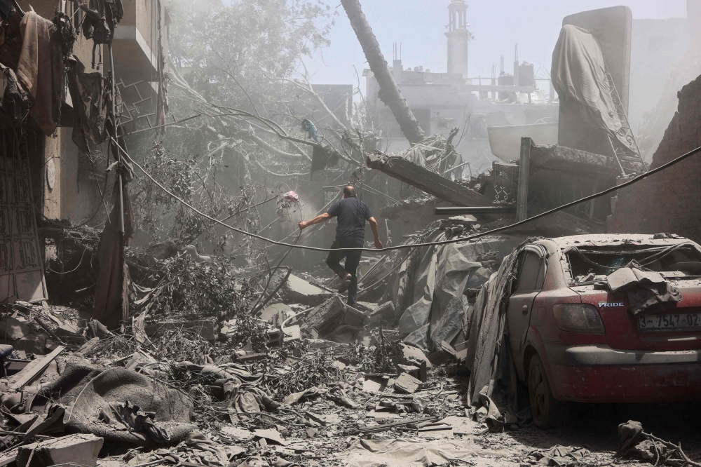 A Palestinian man inspects the rubble following Israeli strikes on the al-Qattaa family home in al-Tuffah neighbourhood in Gaza City May 31, 2025. — AFP pic