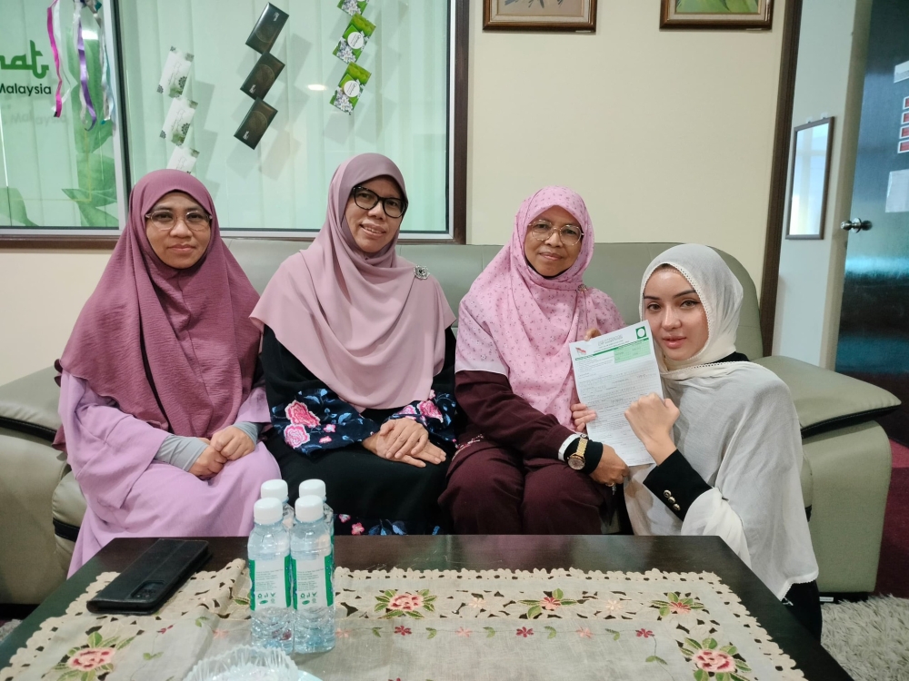 Nur Fathiah Syazwana Shaharuddin, or Cleopatra (rightmost) submits her application to the Muslimat wing of PAS on May 31, 2025. — Picture from Facebook/Dewan Muslimat PAS Malaysia