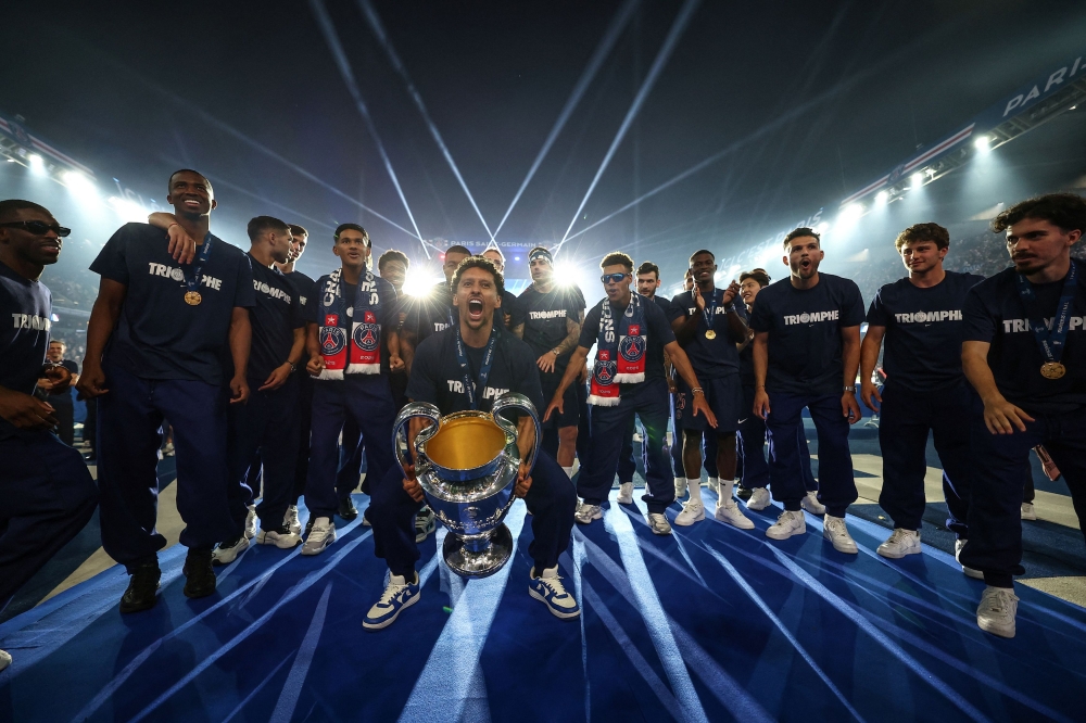 Paris St Germain’s Marquinhos celebrates with supporters and teammates during a ceremony to present the trophy a day after the club won the Uefa Champions League at the Paris St Germain Victory Parade in Paris, June 1, 2025. — Reuters pic 