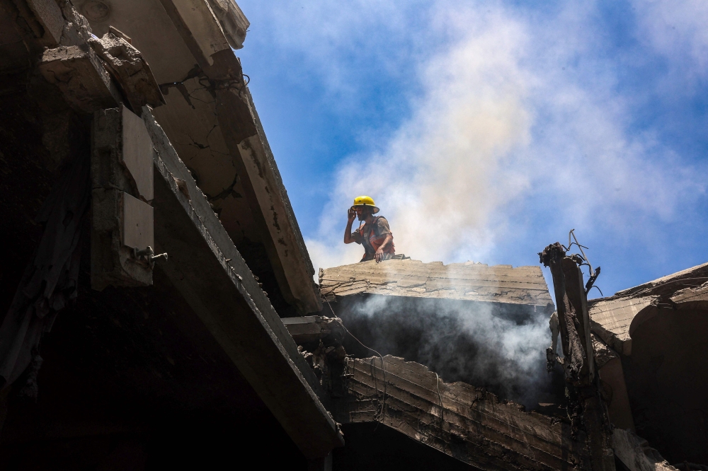 A rescuer stands on the rubble of the al-Bursh family home, after it was targeted in an Israeli strike in Jabalia in the northern Gaza Strip on June 2, 2025. — AFP pic 