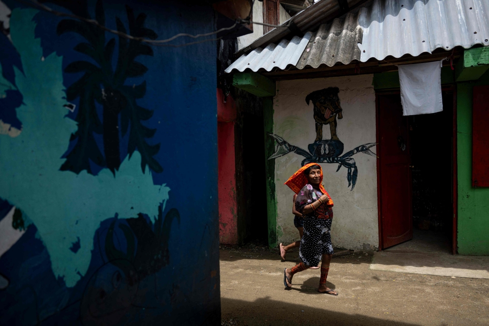 An Indigenous Guna woman walks through a street at Gardi Sugdub island, in the Guna Yala Archipelago, Panama on May 27, 2025. — AFP pic