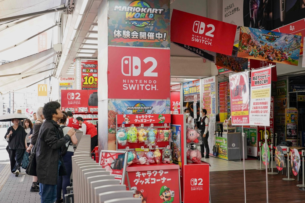 A man checks out the special sales corner for Nintendo Switch 2 in front of an electronics retailer in Tokyo on June 5, 2025. With shops planning midnight launch parties after a run on pre-orders, Nintendo releases the Switch 2 on June 5, hoping to score record early sales for the games console. — AFP pic