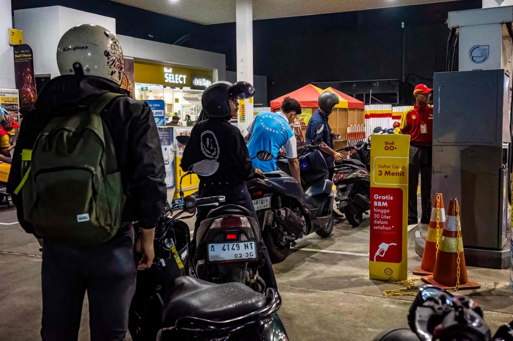 Motorcyclists queue to refill their tanks with fuel at a gas station, during rush hour in Jakarta on June 3, 2025. Indonesia began rolling out a US$1.5 billion stimulus package Thursday to boost consumer activity after South-east Asia’s biggest economy posted its slowest growth in more than three years in the first quarter. — AFP pic