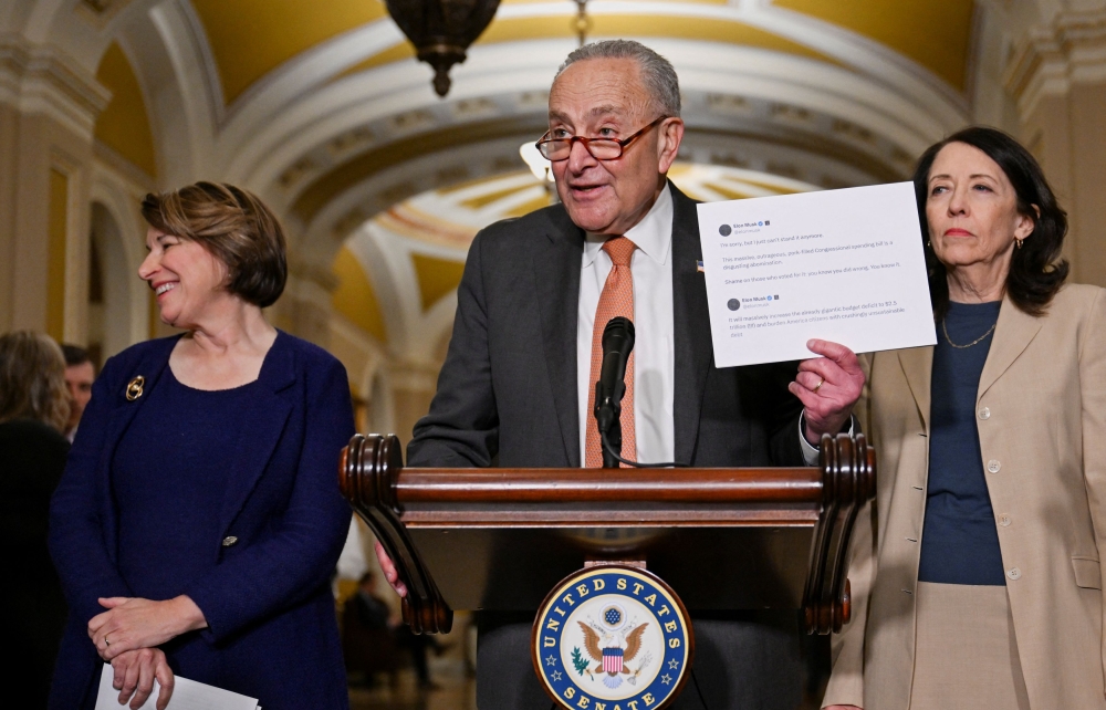 US Senate Minority Leader Chuck Schumer (D-NY) holds up a printout of two posts made by Elon Musk on the social media platform X during a press conference following the weekly policy luncheon, on Capitol Hill in Washington, DC, June 3, 2025. — Reuters pic 