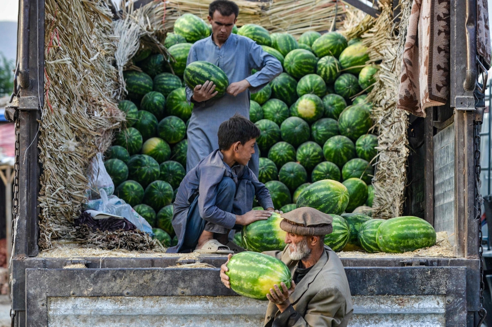 Afghan labourers unload watermelons from a truck at a market in the Fayzabad district of Badakhshan province on June 2, 2025.  — AFP pic