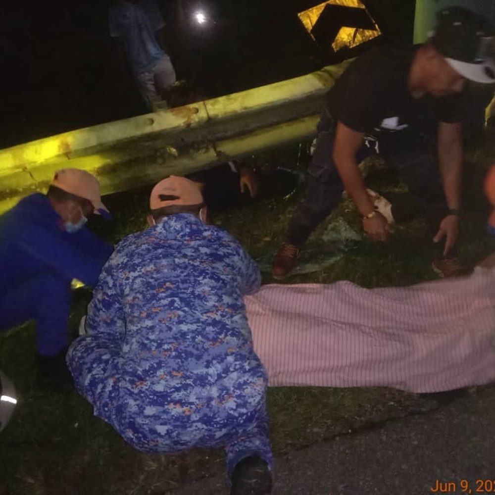 Civil Defence Force personnel attend to the injured and deceased at the scene of the bus-Perodua Alza collision on the East-West Highway near Tasik Banding, Gerik in Perak on June 9, 2025. — Bernama pic